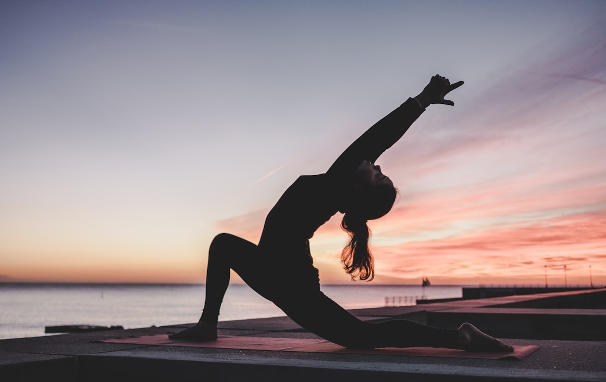 Woman in spiritual yoga pose at sunset — the peace and freedom Reiki can bring